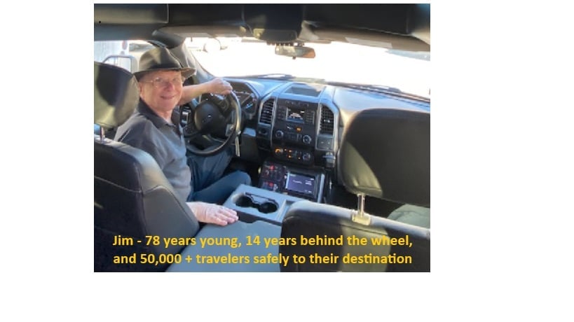 Older man in baseball cap sitting in drivers seat of pickup truck. Jim - 78 years young, 14 years behind the wheel, and 50,000+ travelers safely to their destination